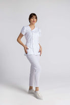 Costum Medical Elastic de culoare albă, cu un design elegant cu nasturi și o croială lejeră, perfect pentru profesioniștii din domeniul sănătății.