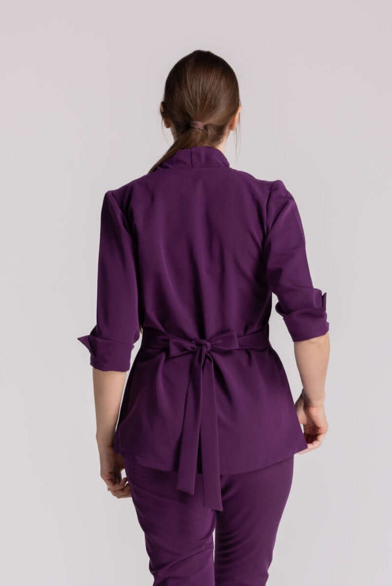Bluza Elastica Elise in violet, cu guler shal și cordon ajustabil, perfectă pentru profesioniștii medicali.
