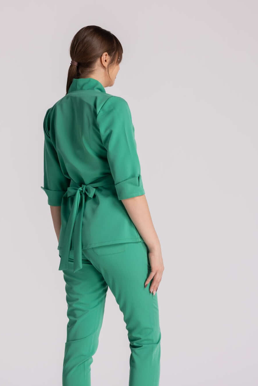 Bluza Medicala Elastica Elise - imaginea arată spatele unei femei purtând o bluză medicală verde cu pantaloni asortați.