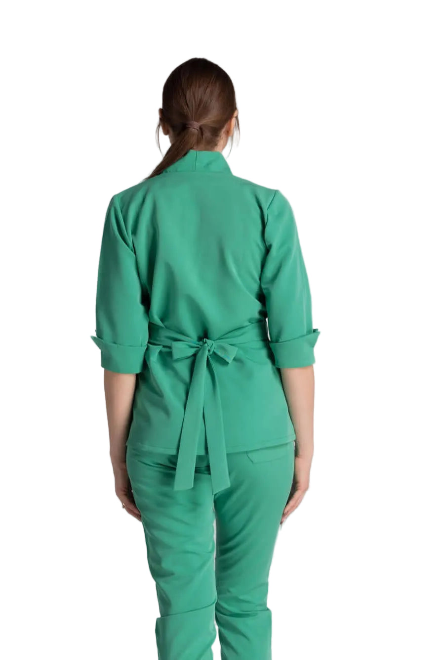 Bluza Medicala Elastica Elise - femeie îmbrăcată în bluza medicală verde, cu spatele la cameră, detaliu cu fundă