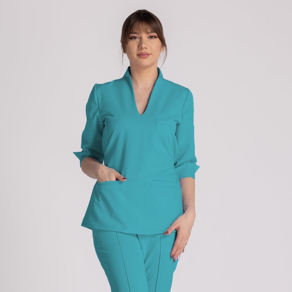 Bluza Elastica Elise - bluză medicală elegantă, cu guler shal și buzunare prietenoase, în nuanță turcoaz.
