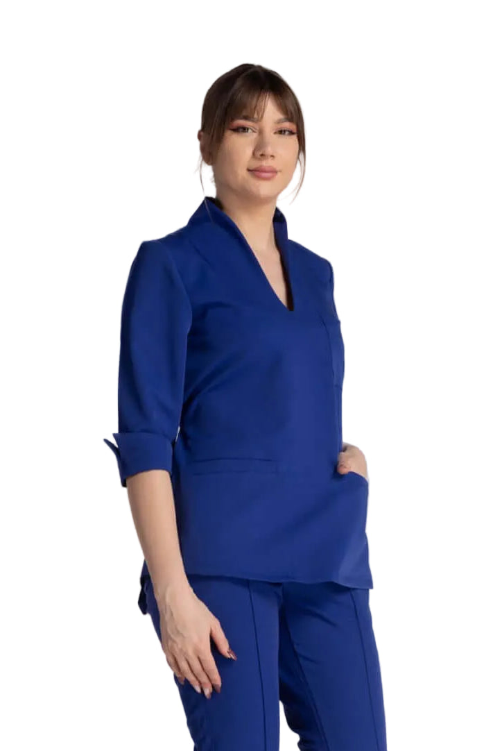 Bluza Elastica Elise - bluză medicală albastră cu guler shal și buzunare pentru instrumente.